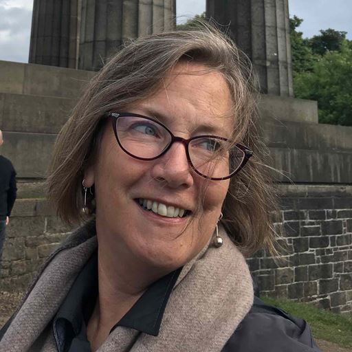 Donna Graves looking happy outside, in front of some ancient ruins