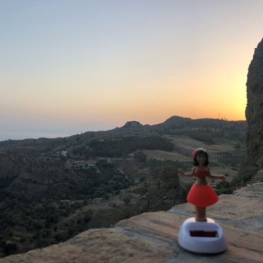 image of mountainous countryside at dusk with a toy doll in the foreground