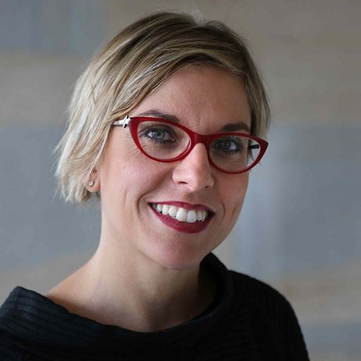 Dr Paola Di Giuseppantonio Di Franco, smiling and looking happy, wearing red glasses