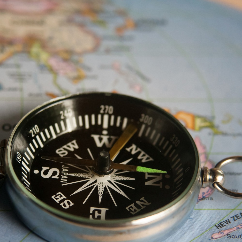 A compass on a world map, signifying the difference between the Global South and Global North.