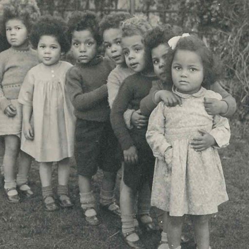 A group of mixed race toddlers lined up looking nervous