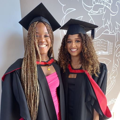 Two graduating students celebrating