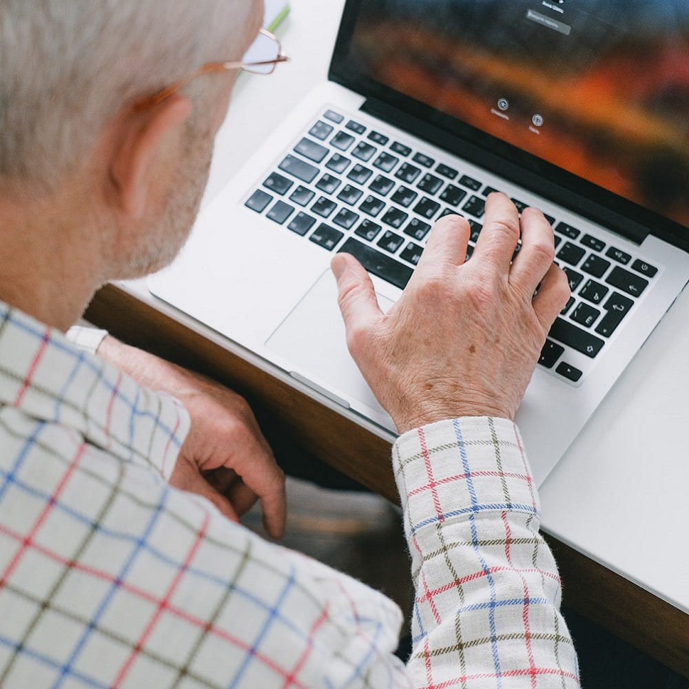 An older man on a laptop learning a language.
