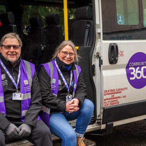 Image of male and female volunteers sitting on the edge of a Community360 minibus