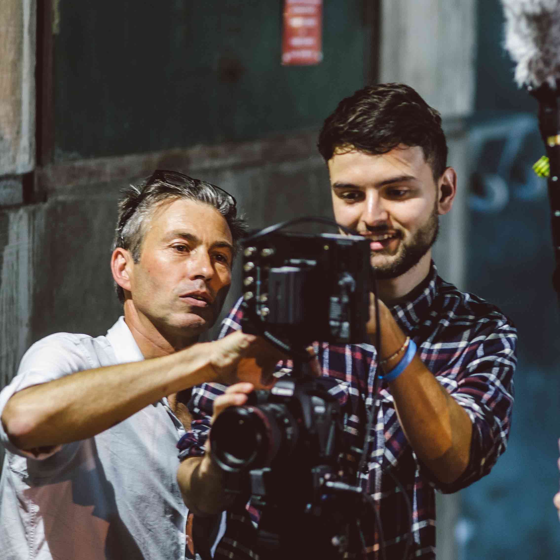 A film studies lecturer helps a students set up a video camera for a shot