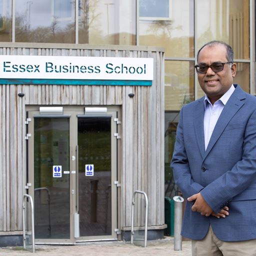 Picture of Professor Shahzad Uddin standing outside the Essex Business School building in Colchester