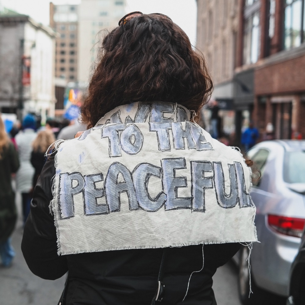 Back view of woman holdng peace banner over her shoulders