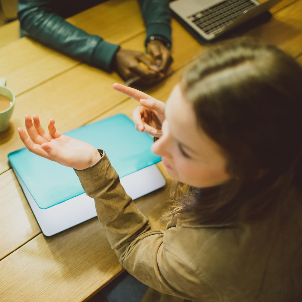 students sit at desk with laptop