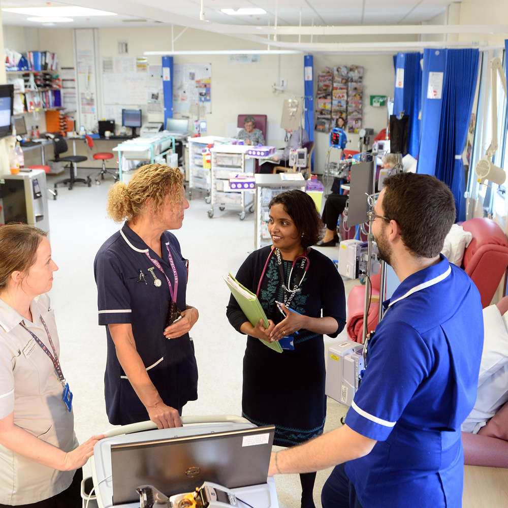 Health professionals talking in hospital ward