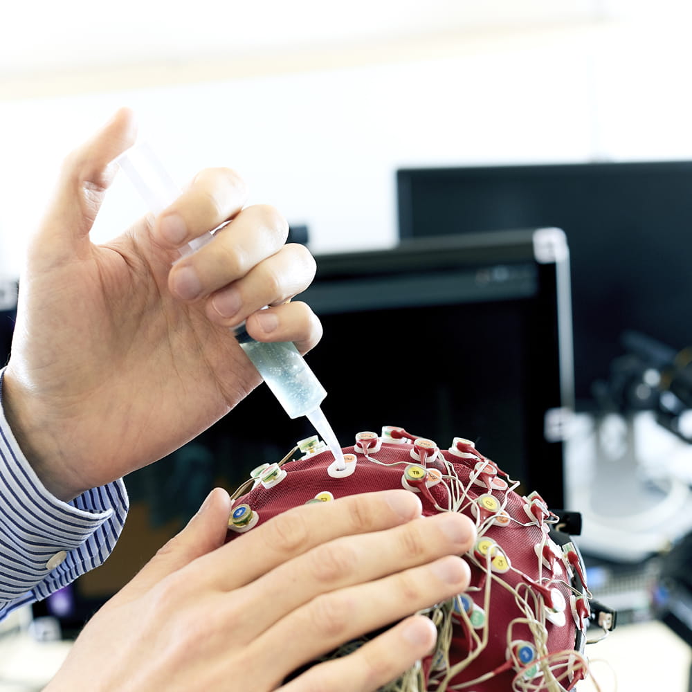 Man injecting fluid into a EEG cap