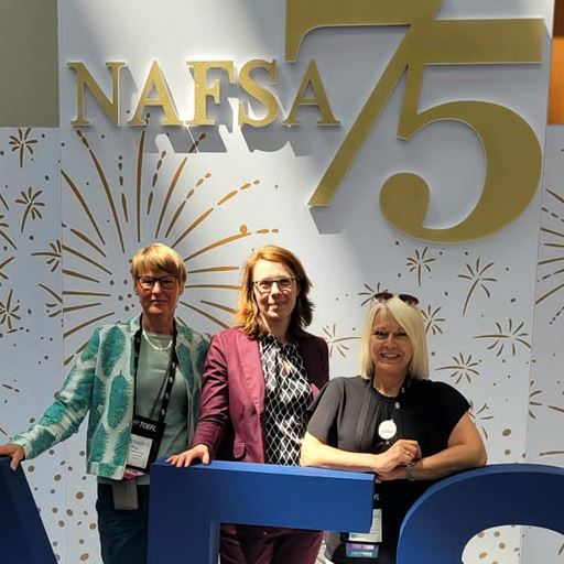 Birgit Siebe-Herbig, Dr Mandy Boehnke and Karen Bush standing in front of NAFSA logo