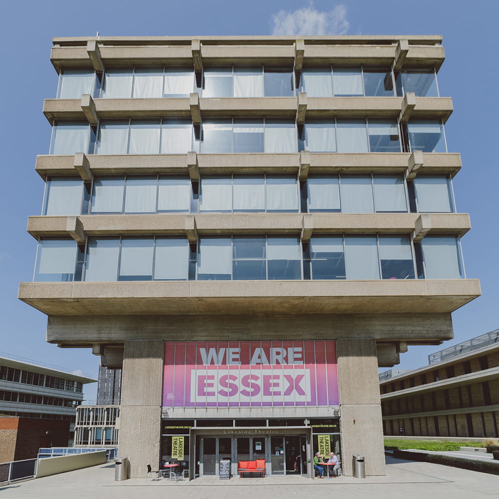 Front aspect of the Albert Sloman Library on a sunny day with blue skies. The lower windows read "WE ARE ESSEX" in purple and white text.