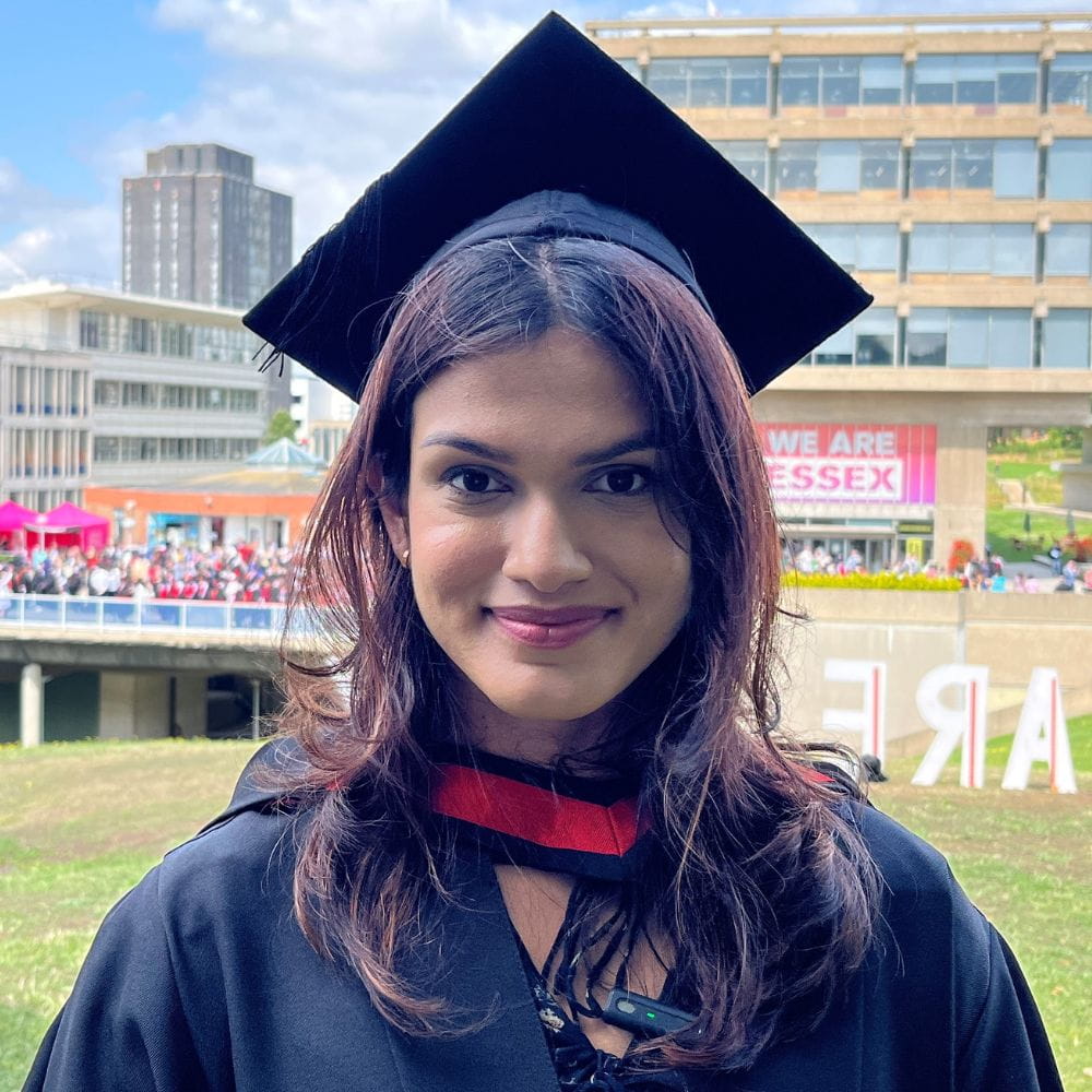 Zaiba Tahyya Essex Alumna of the Year 2023 in front of the University library in her graduation robes