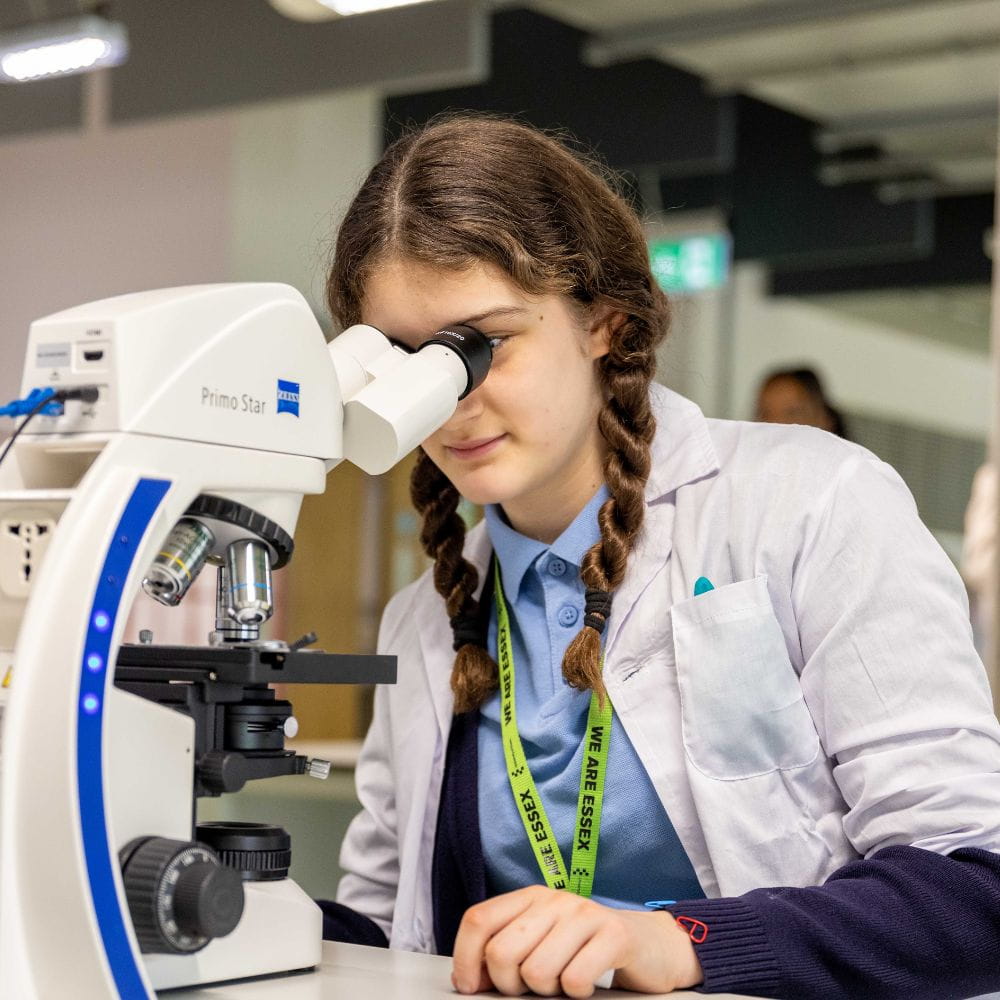 A child peers into a microscope
