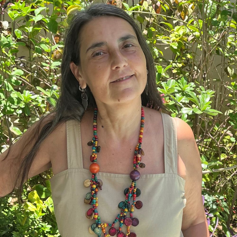 Professor Maria Cristina Fumagalli, looking relaxed in sun-dappled shade in a garden