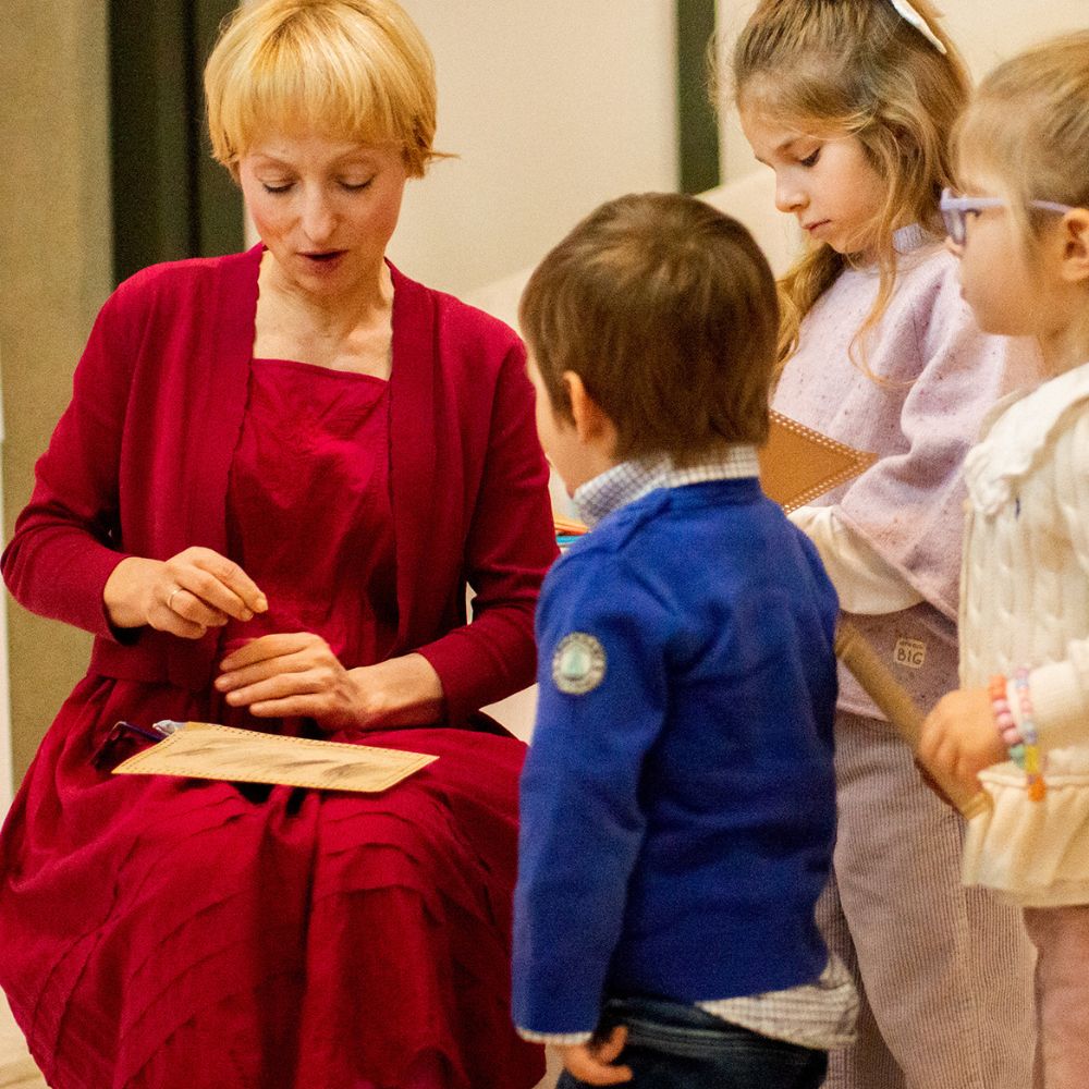 Professor Sanja Bahun, seated, talking to a group of small children