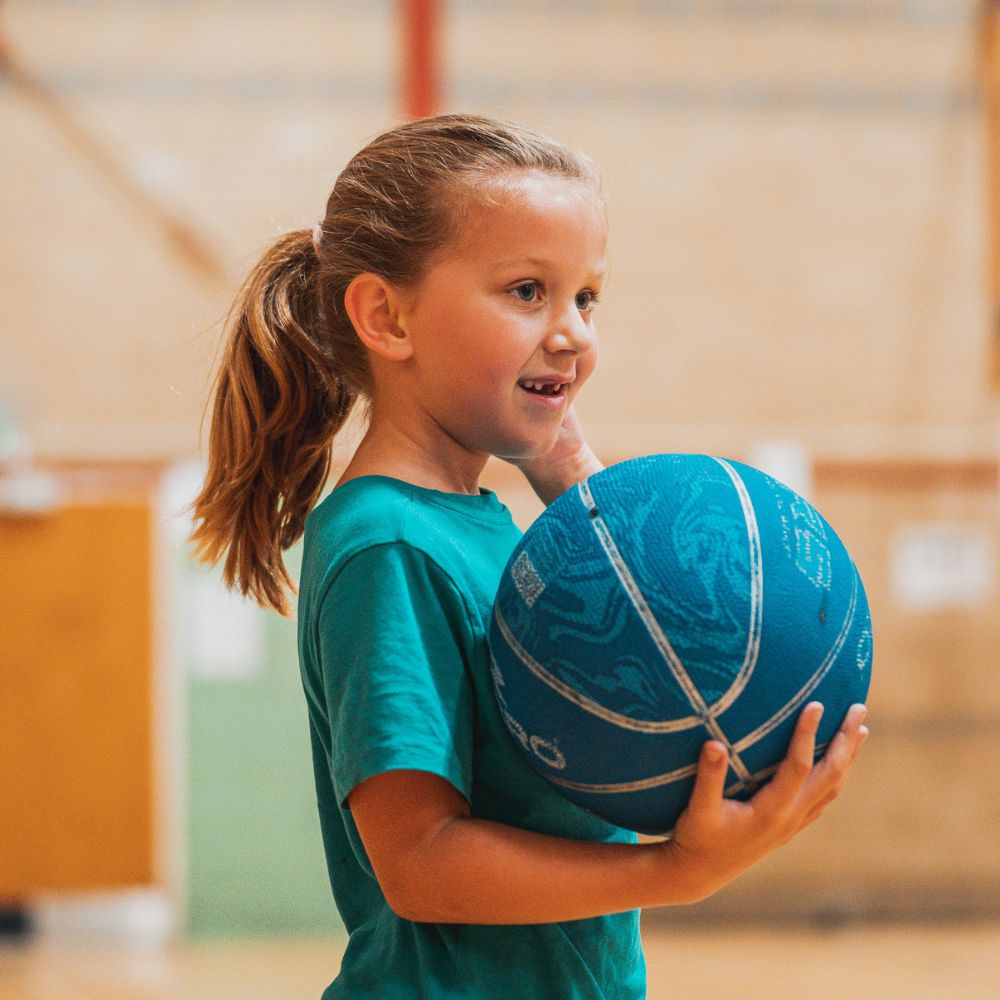 A girl learns to play basketball