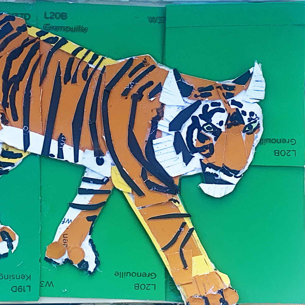 A cut out print of a tiger in an abstract style, sitting on a green cutting board