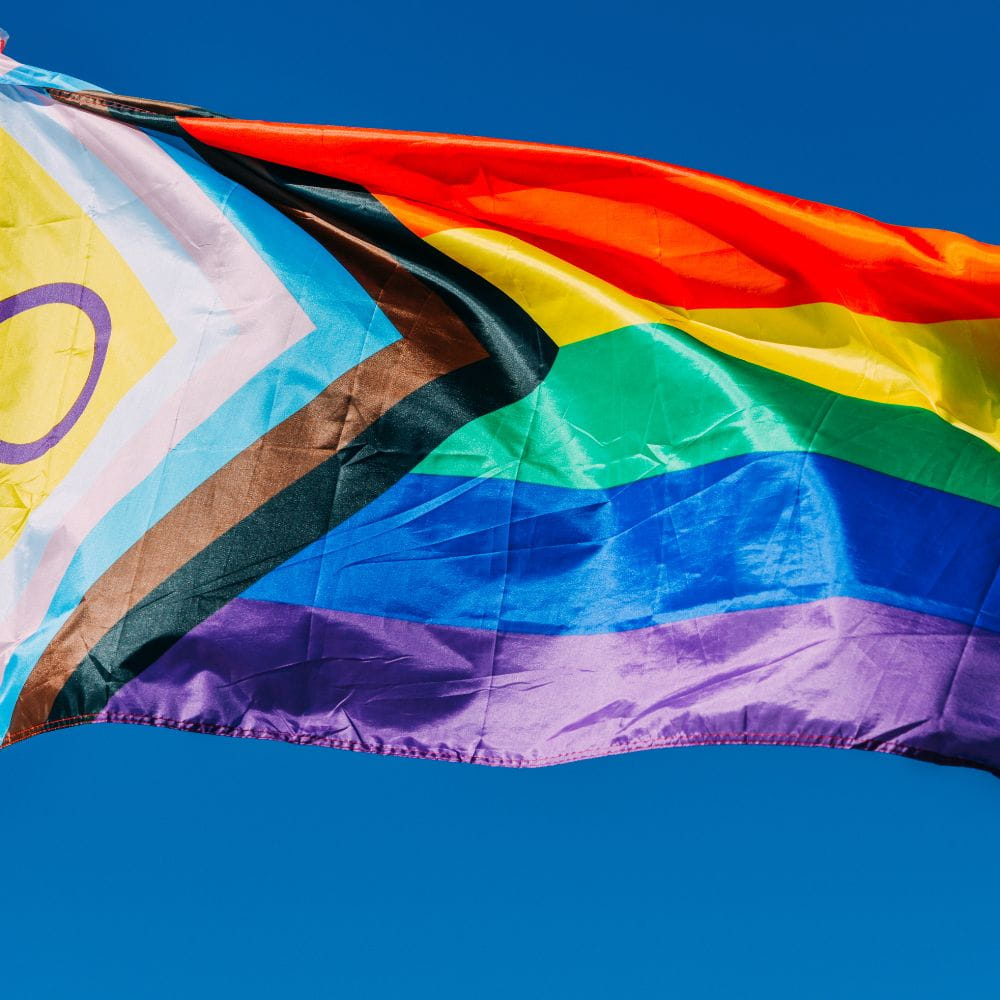 LGBTQ flag in blue sky