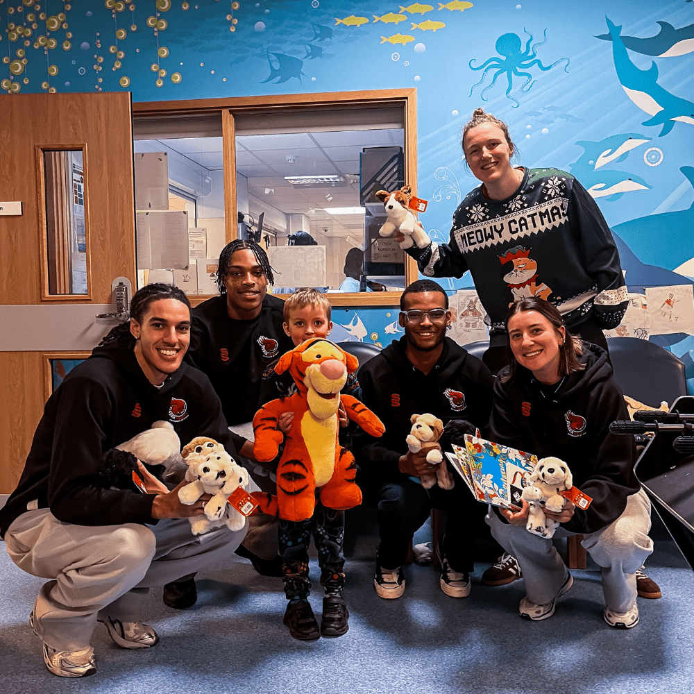 Essex Rebels players pose for a photo with a child at Colchester Hospital