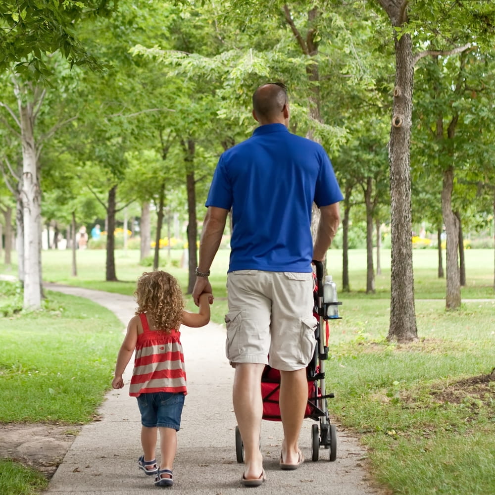 A father walking with his daughter in a park