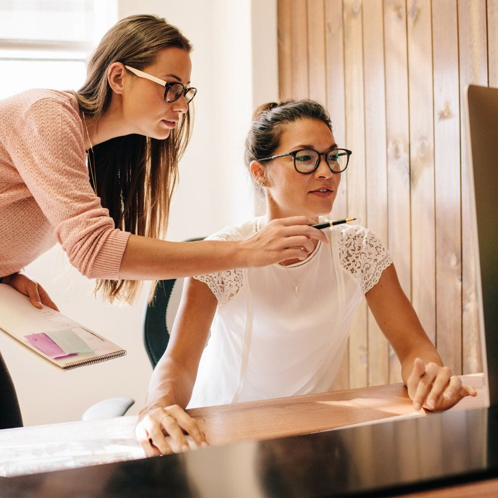 Two women looking at a computer screen in an office