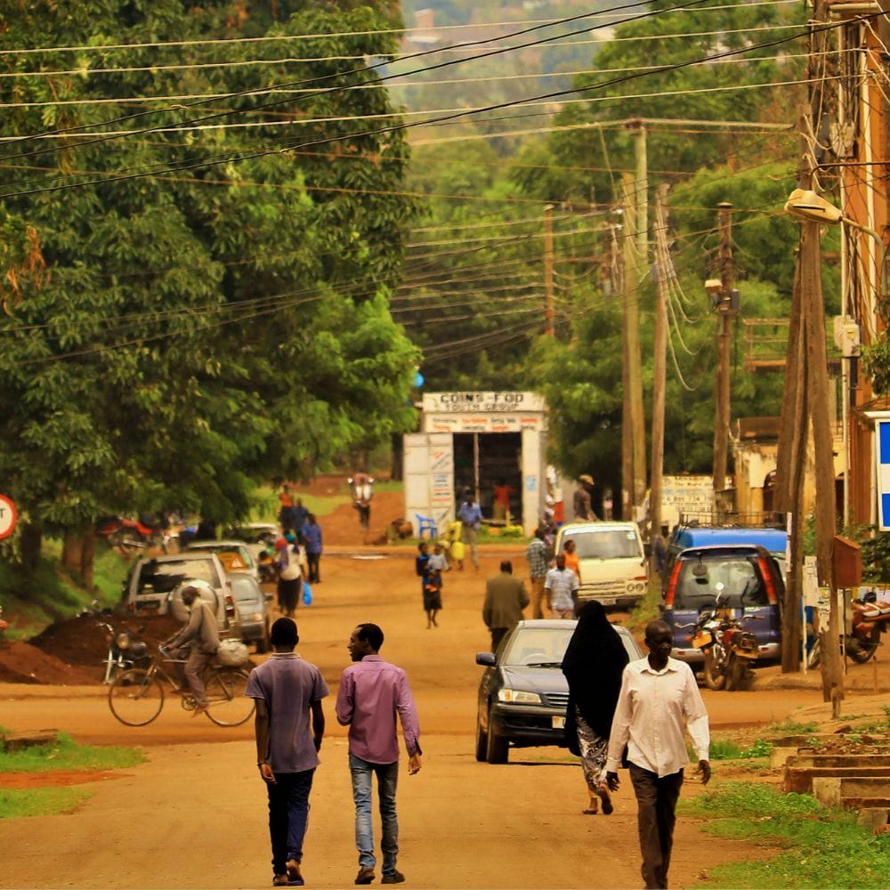 People walking along a dirt road in Uganda