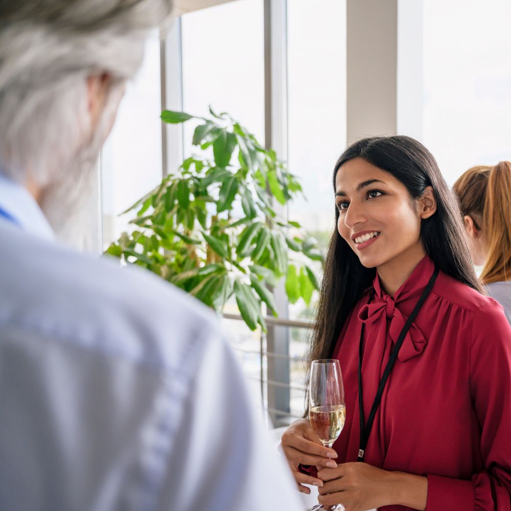 woman with glass of champagne talking to man