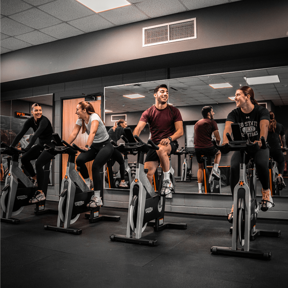 Four students taking part in a cycling class 