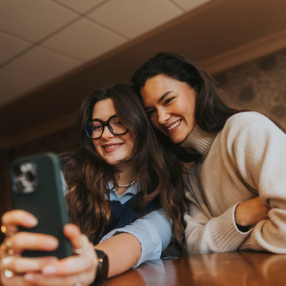 Students looking at phone smiling
