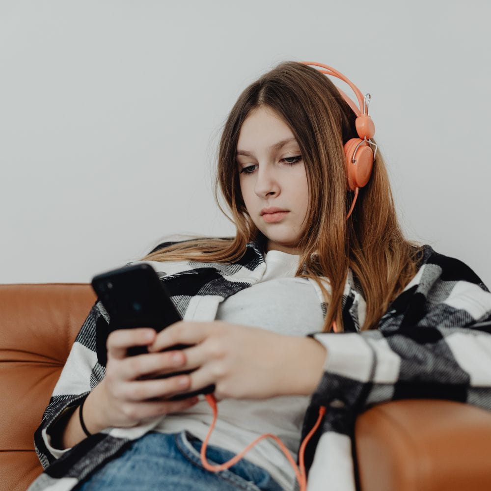 A bored looking woman playing on her phone