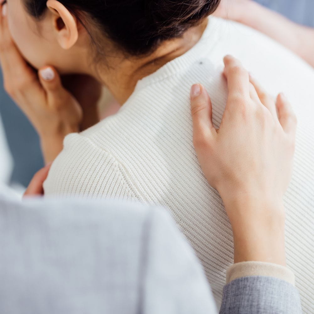Woman being consoled with hand on her shoulder