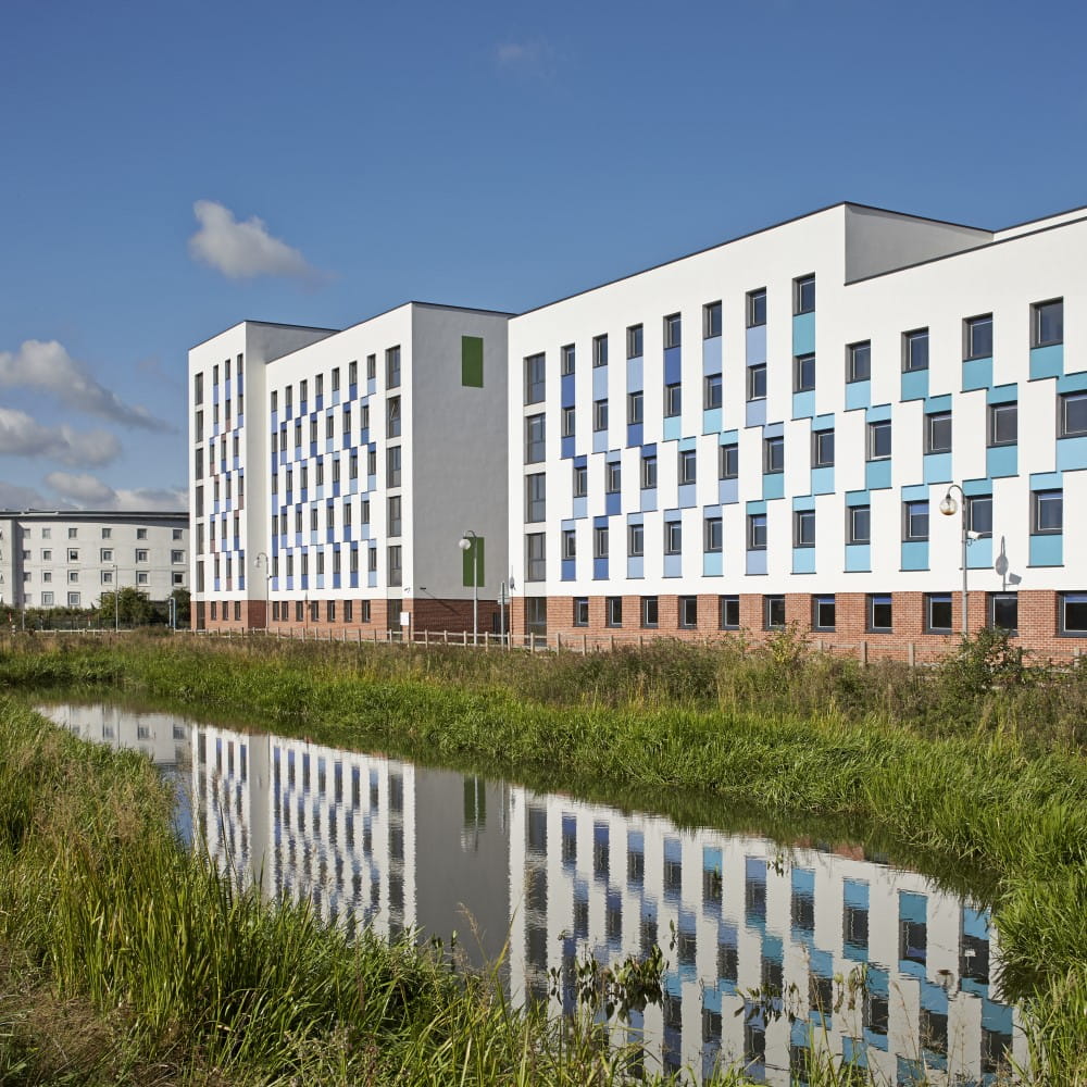  white block of flats among green grass