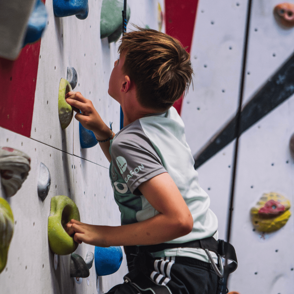 Kid climbing an indoor climbing wall