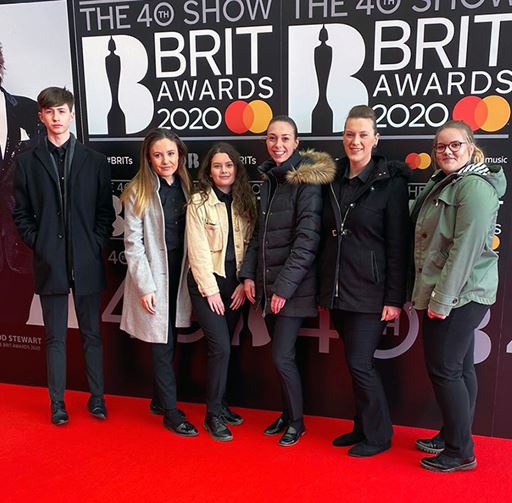 Students from the Edge Hotel School standing on the BRITs red carpet