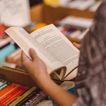 Person reading a book taken from a box of books