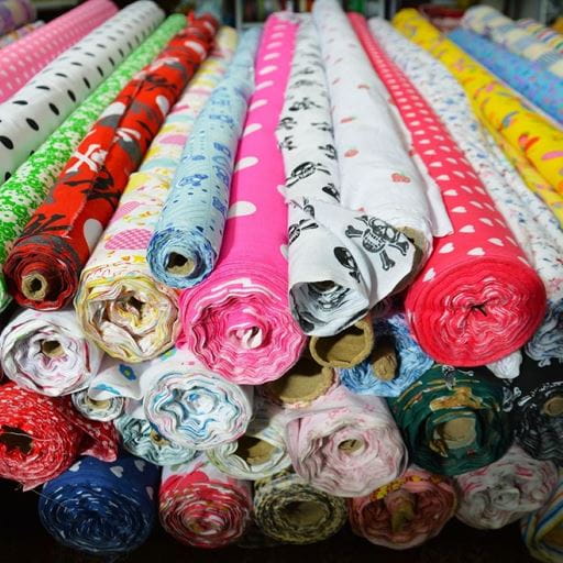 An image of lots of different coloured rolls of material