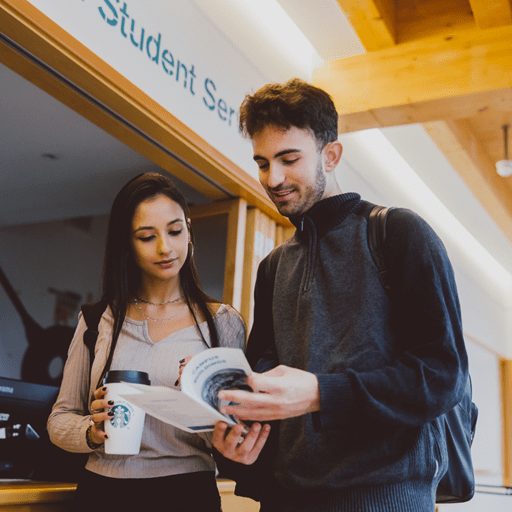 Two students discussing a brochure