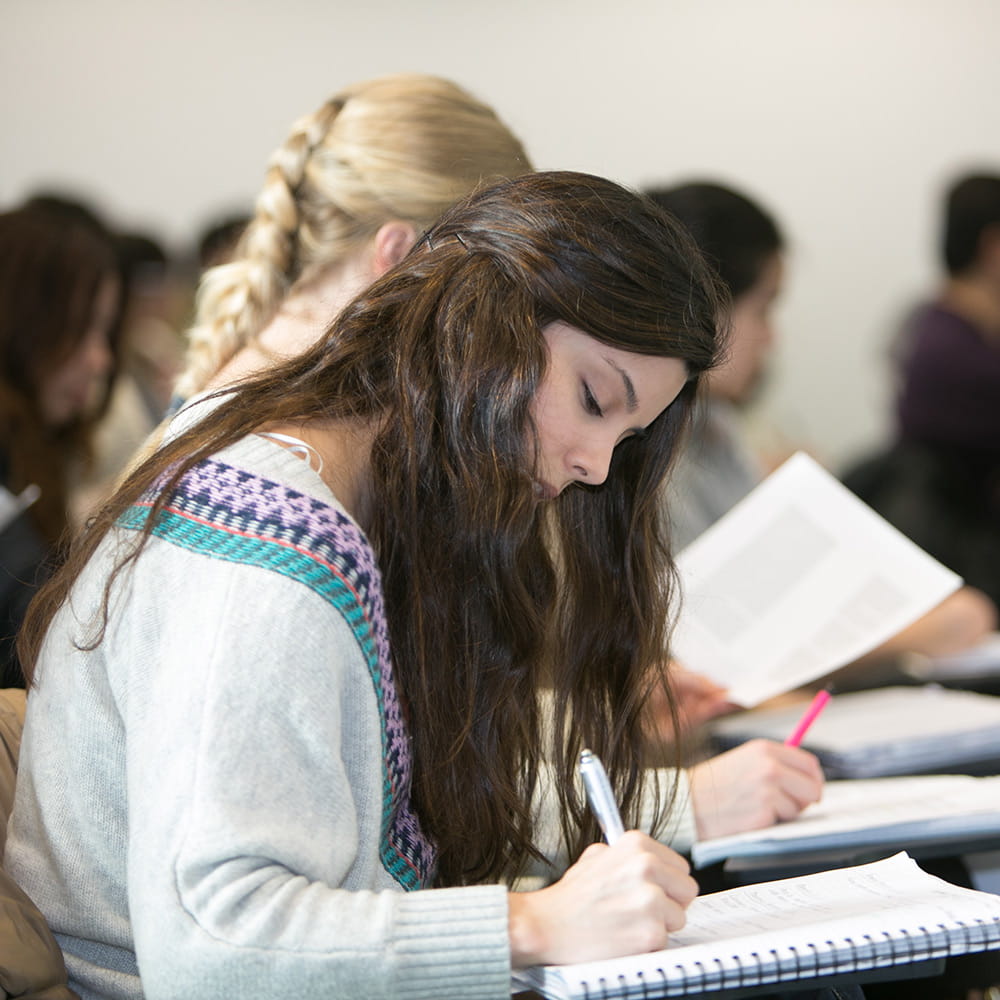 Student writing in a lecture 