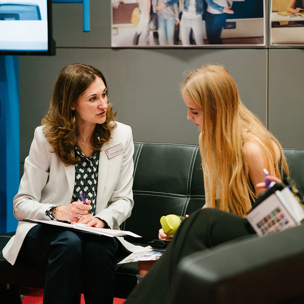 Image of an academic member of staff chatting with a prospective student at an open day