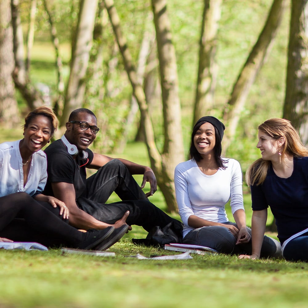 A group of students laughing together by the lakes