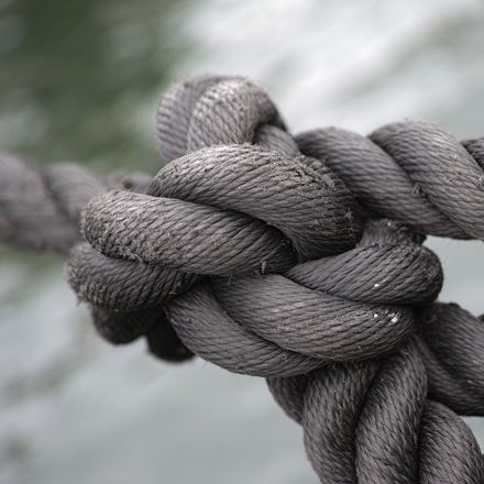 A thick piece of twisted brown rope tied in to a large knot.