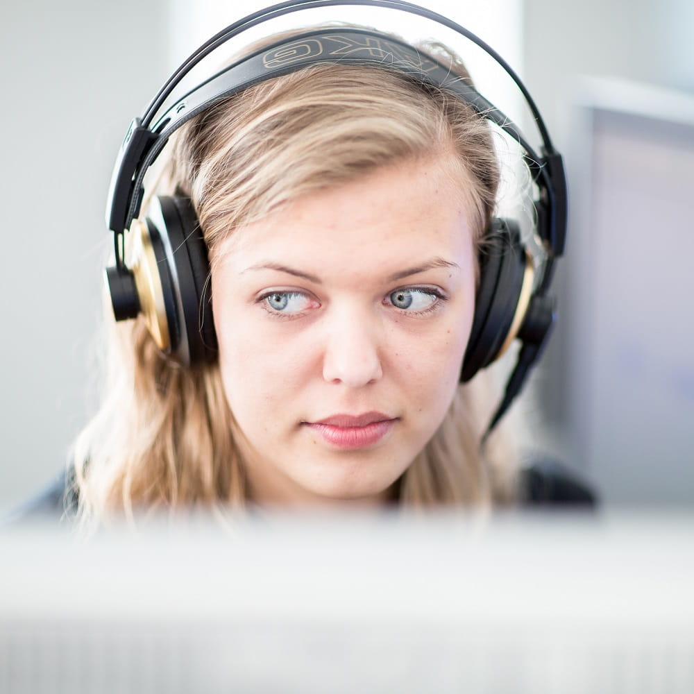 A woman wearing headphones looking away from the camera.