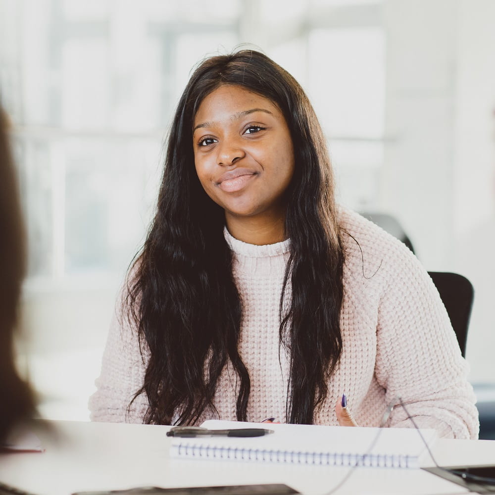 A student looking across at a person mostly out of shot, just to the left of the photographer.