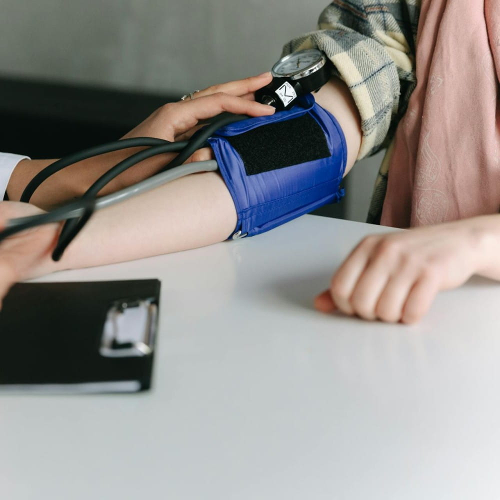 A person, mostly out of shot, having their blood pressure checked.