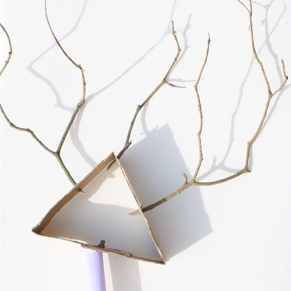 A cardboard triangle with sticks coming out of it.