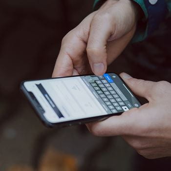 Hands holding mobile phone and scrolling on social media
