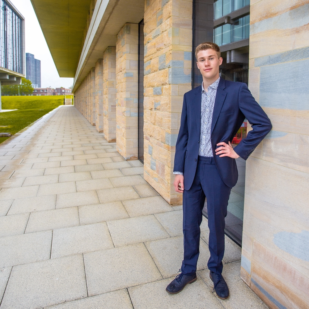 Man wears suit in front of building