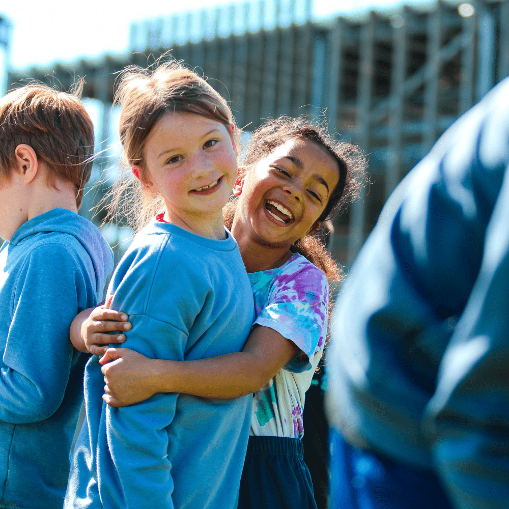 Sunny day outside with Two kids smiling and hugging  