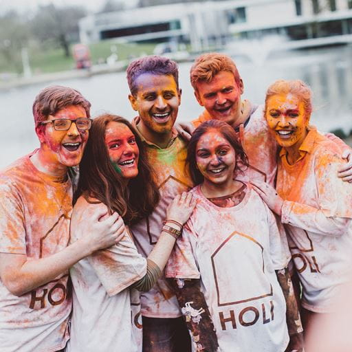 Students covered in holi-paint smiling